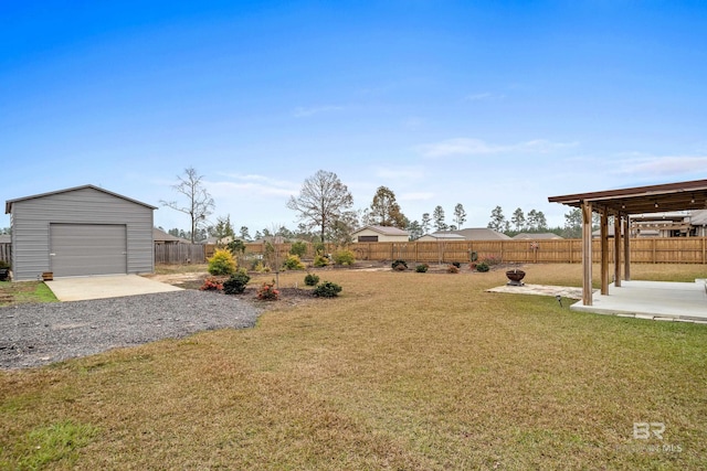 view of yard featuring an outbuilding, a garage, and a patio area