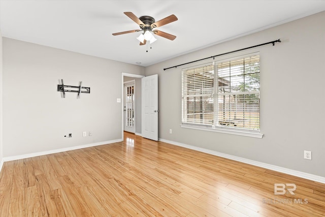 empty room featuring light wood-type flooring, ceiling fan, and baseboards