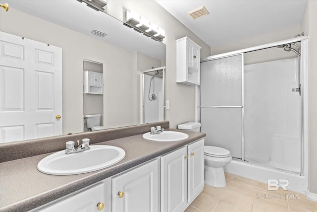 bathroom featuring toilet, a shower stall, visible vents, and a sink