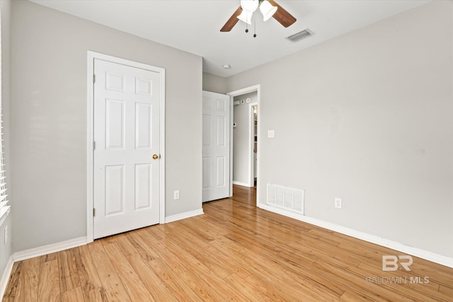 unfurnished bedroom with a ceiling fan, light wood-style flooring, visible vents, and baseboards