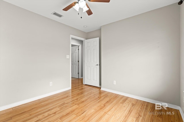 spare room with light wood-style floors, baseboards, visible vents, and ceiling fan