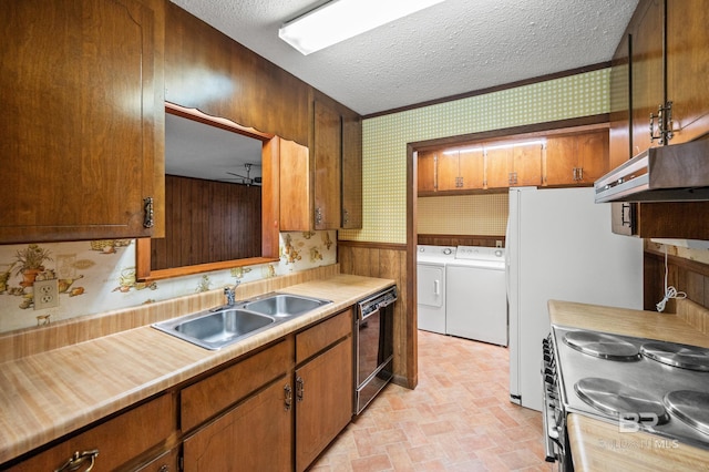 kitchen featuring a textured ceiling, washing machine and clothes dryer, stainless steel range, sink, and ventilation hood