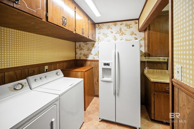 laundry room with independent washer and dryer, ornamental molding, and cabinets