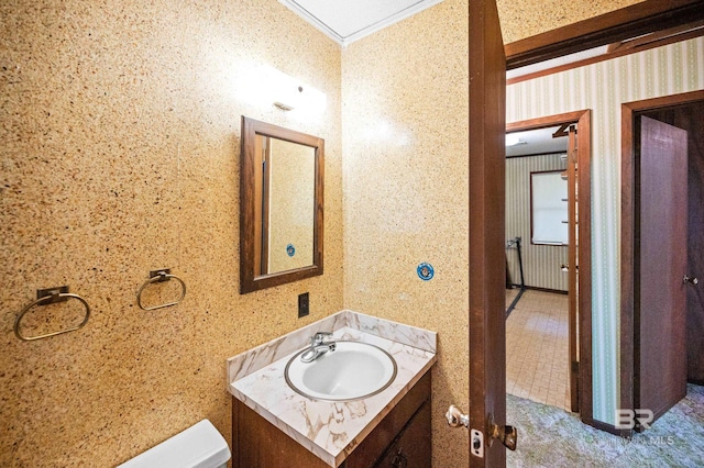 bathroom featuring vanity, ornamental molding, and toilet