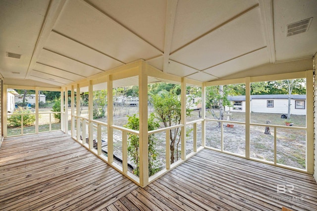 unfurnished sunroom featuring vaulted ceiling