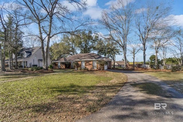 view of front of house featuring an attached garage, a front lawn, and aphalt driveway