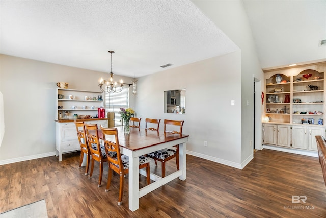 dining area with visible vents, dark wood-type flooring, a textured ceiling, a chandelier, and baseboards