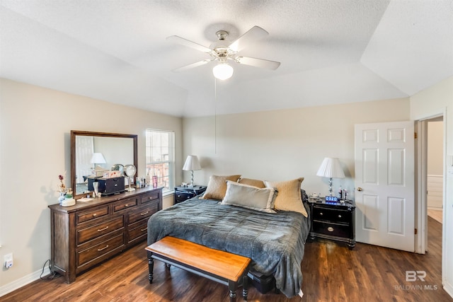 bedroom with lofted ceiling, ceiling fan, baseboards, and dark wood finished floors