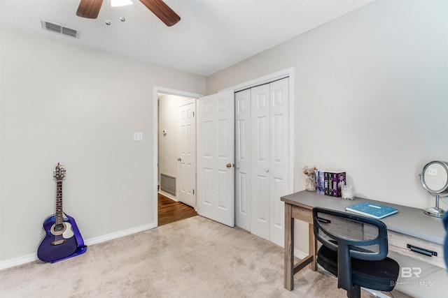 home office featuring baseboards, carpet flooring, visible vents, and a ceiling fan