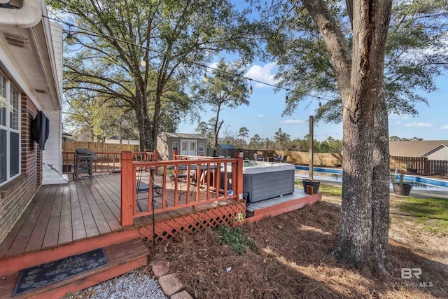 wooden deck with a fenced backyard, a grill, and a fenced in pool