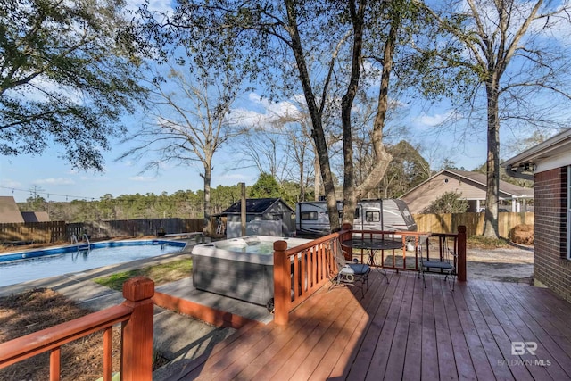 deck featuring a hot tub, a fenced backyard, and a fenced in pool