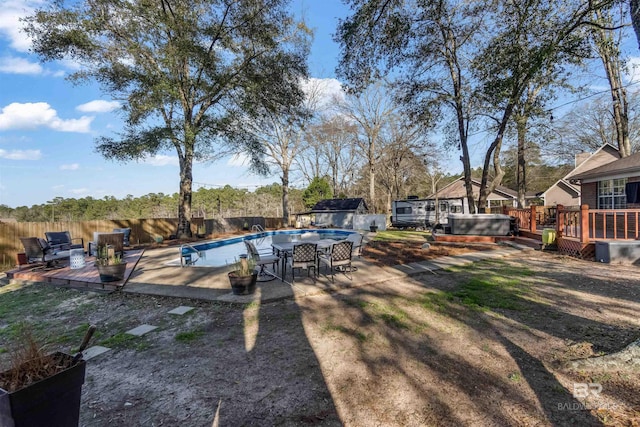 view of yard with a fenced backyard, a wooden deck, and a hot tub