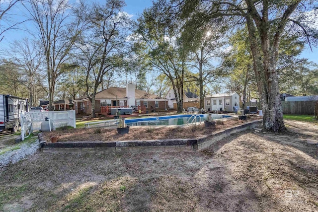 view of yard with an outdoor structure, fence, and a fenced in pool