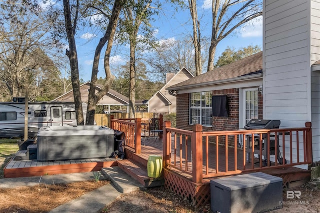 wooden deck with grilling area, fence, and a hot tub