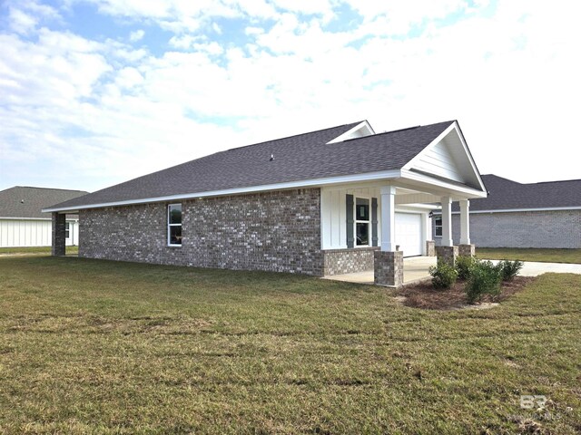 view of side of home with a garage and a yard