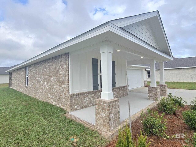 view of side of property with a lawn and a garage