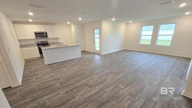 kitchen featuring white cabinetry, hardwood / wood-style flooring, an island with sink, appliances with stainless steel finishes, and sink