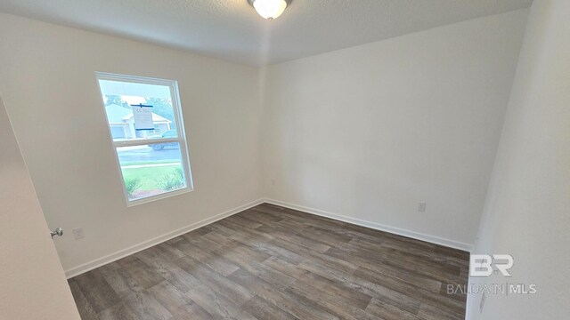 empty room with dark wood-type flooring and plenty of natural light