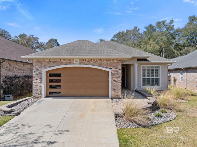 view of front of property featuring a garage, concrete driveway, roof with shingles, and brick siding