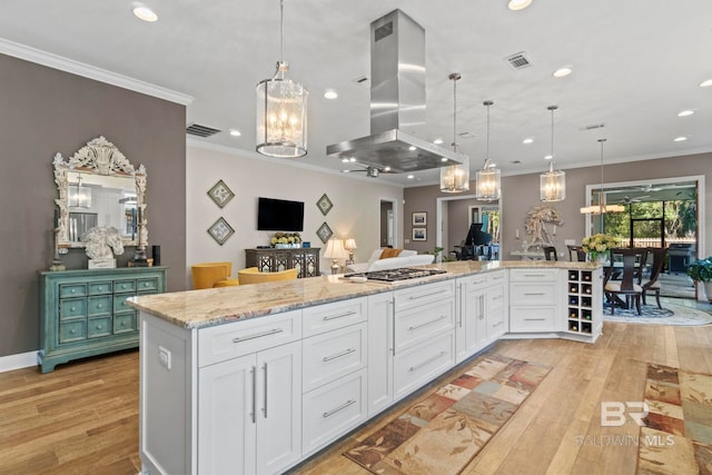 kitchen featuring visible vents, open floor plan, white cabinetry, island range hood, and light wood-type flooring