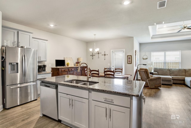 kitchen with a sink, wood finished floors, visible vents, and stainless steel appliances