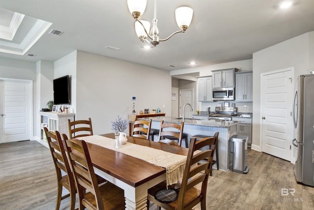 dining room with an inviting chandelier, recessed lighting, visible vents, and light wood-type flooring