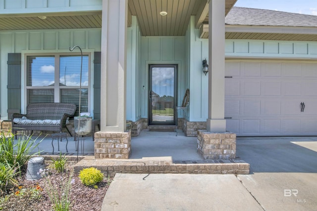 entrance to property with driveway, a porch, an attached garage, a shingled roof, and board and batten siding