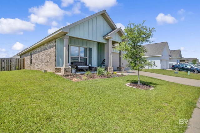 view of front of house featuring a front lawn, board and batten siding, driveway, and fence