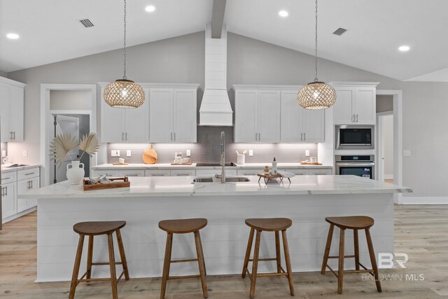 LOT9 Tall Timber Ln, Elberta, AL 36530 - kitchen featuring stainless steel appliances, light wood-type flooring, a kitchen island with sink, white cabinetry, and a breakfast bar area