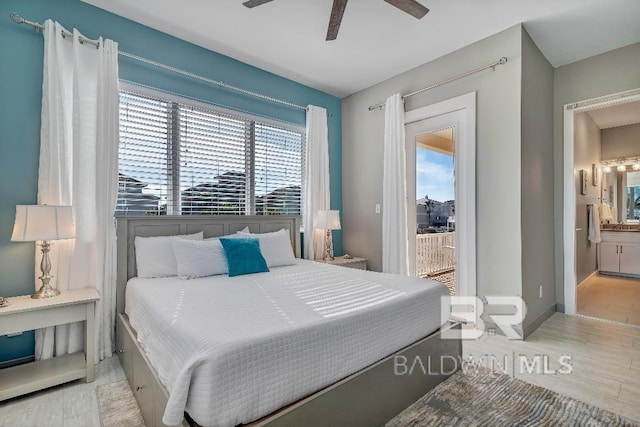 bedroom with multiple windows, ceiling fan, ensuite bath, and light wood-type flooring
