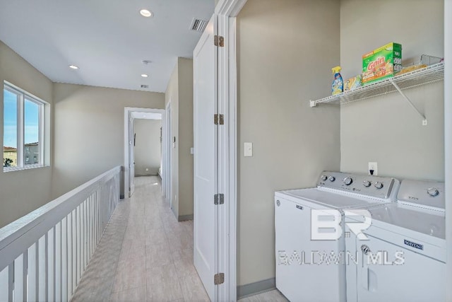 washroom with washing machine and dryer and light hardwood / wood-style flooring