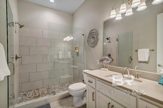 bathroom with tile patterned floors, vanity, toilet, and a shower with door