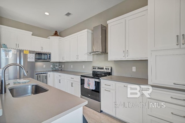 kitchen featuring sink, white cabinets, stainless steel appliances, and wall chimney range hood
