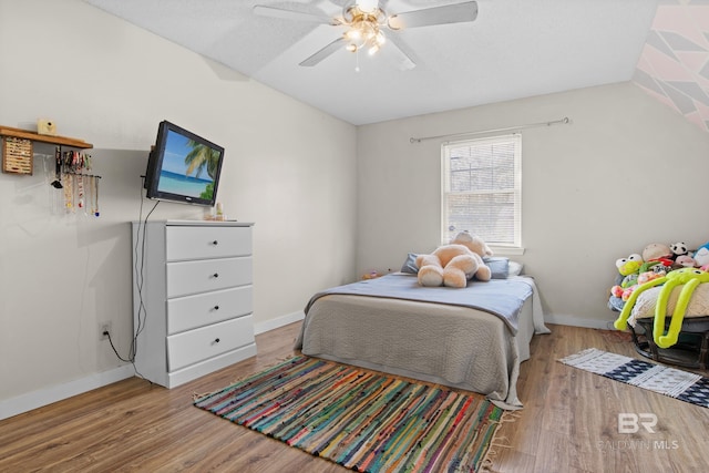 bedroom with ceiling fan, vaulted ceiling, and light hardwood / wood-style flooring