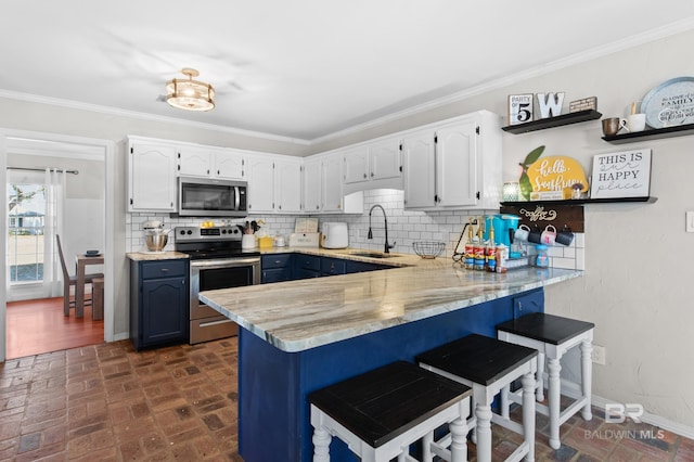 kitchen with sink, white cabinetry, ornamental molding, kitchen peninsula, and stainless steel appliances