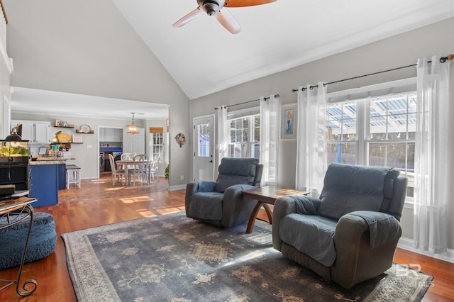 living room featuring high vaulted ceiling, dark hardwood / wood-style floors, and ceiling fan