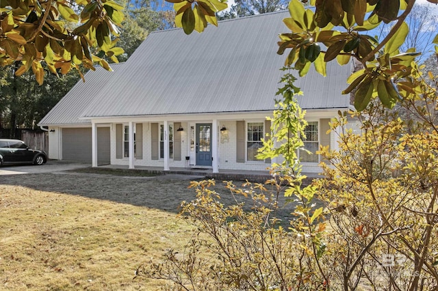 view of front of home featuring a garage, a front lawn, and covered porch