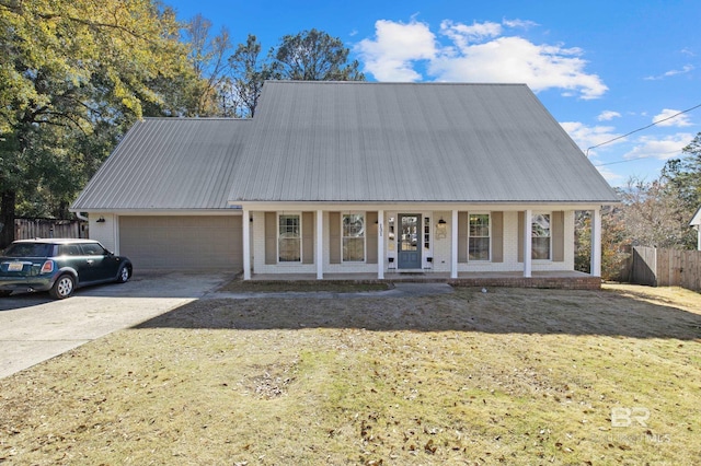 view of front of house with a garage, a front yard, and covered porch