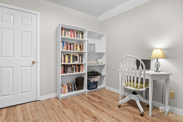 home office with a textured ceiling and light wood-type flooring