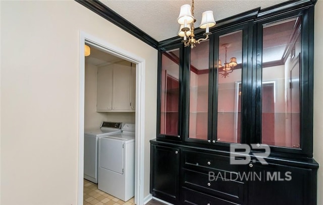 washroom with a chandelier, cabinets, independent washer and dryer, crown molding, and a textured ceiling