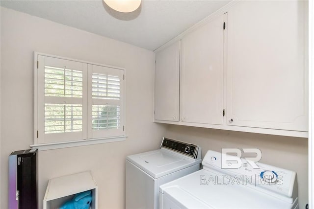 washroom featuring washing machine and dryer and cabinets