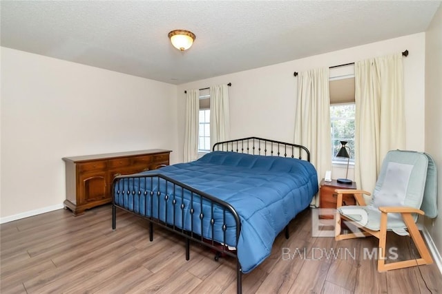 bedroom with hardwood / wood-style floors and a textured ceiling