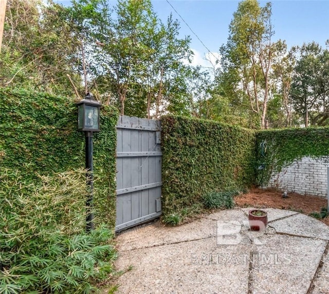 view of gate featuring a patio