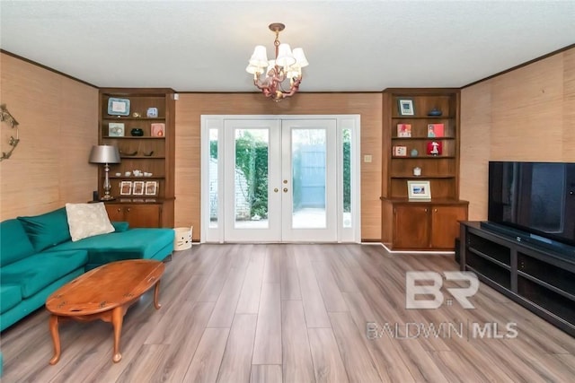 living room featuring hardwood / wood-style floors, an inviting chandelier, and french doors