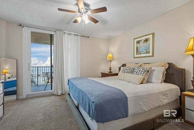 carpeted bedroom featuring ceiling fan, a textured ceiling, and access to exterior