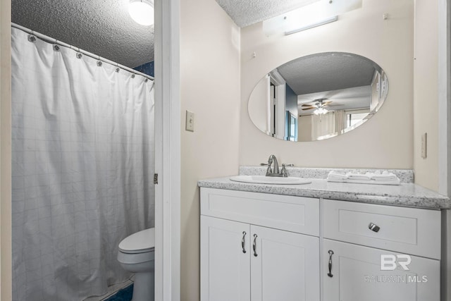 bathroom featuring ceiling fan, vanity, toilet, and a textured ceiling