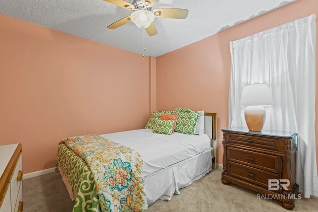 carpeted bedroom with ceiling fan and a textured ceiling