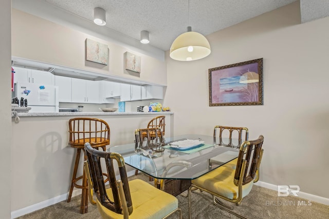 carpeted dining space featuring a textured ceiling