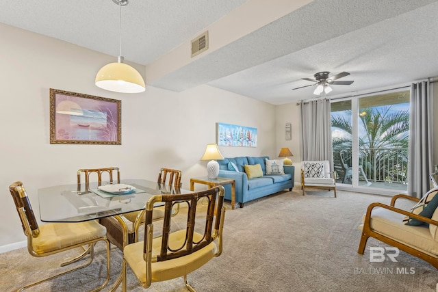 dining area with ceiling fan, a textured ceiling, and light carpet