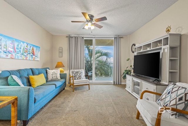 living room with light carpet, ceiling fan, and a textured ceiling